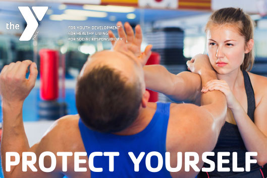 A woman practicing self-defense with a man in a gym, with YMCA logo and slogan.
