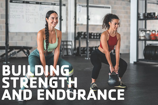 Two women performing kettlebell squats in a gym.