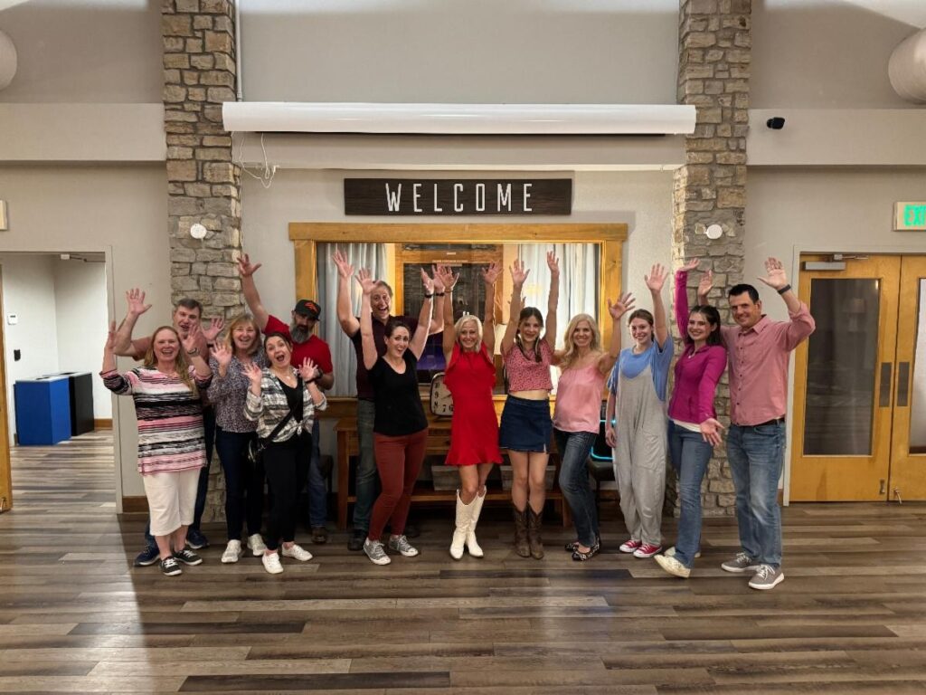 Group of dance participants waving.