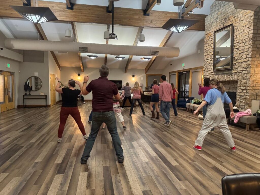 Line dancers facing away from the camera in formation.