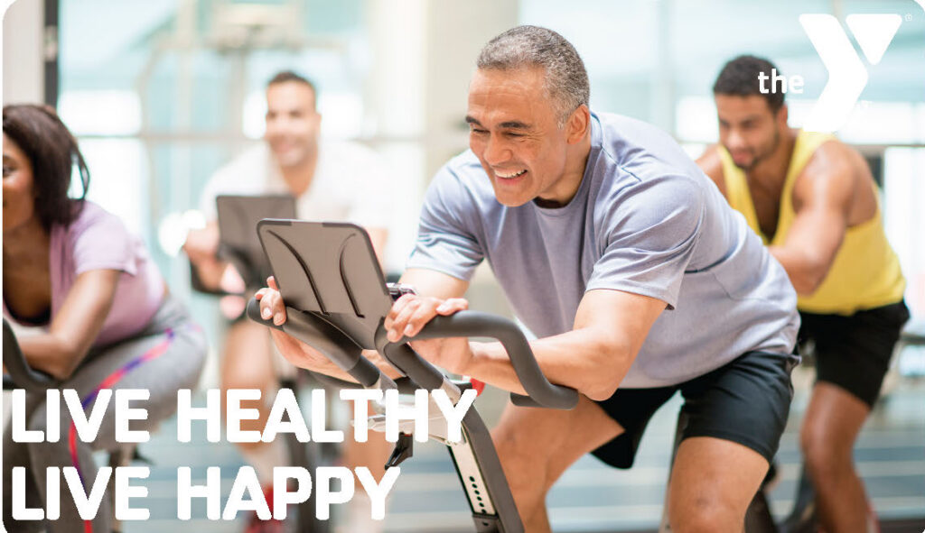 Group of gym cyclers on their bikes smiling.
