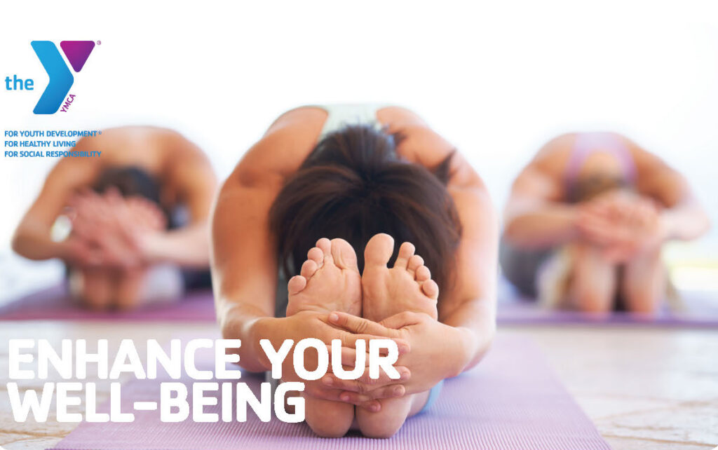 Three people on mats stretching legs with hands on feet.