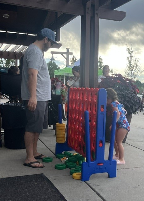 parents and kids playing large Connect 4 game